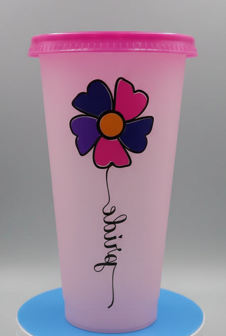 A pink plastic travel tumbler with a magenta lid, featuring a heart-patterned flower and the word 'Pride' printed on the front.