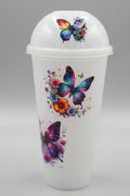 A clear plastic takeaway cup with a matching dome lid, decorated with colorful butterfly and floral designs.